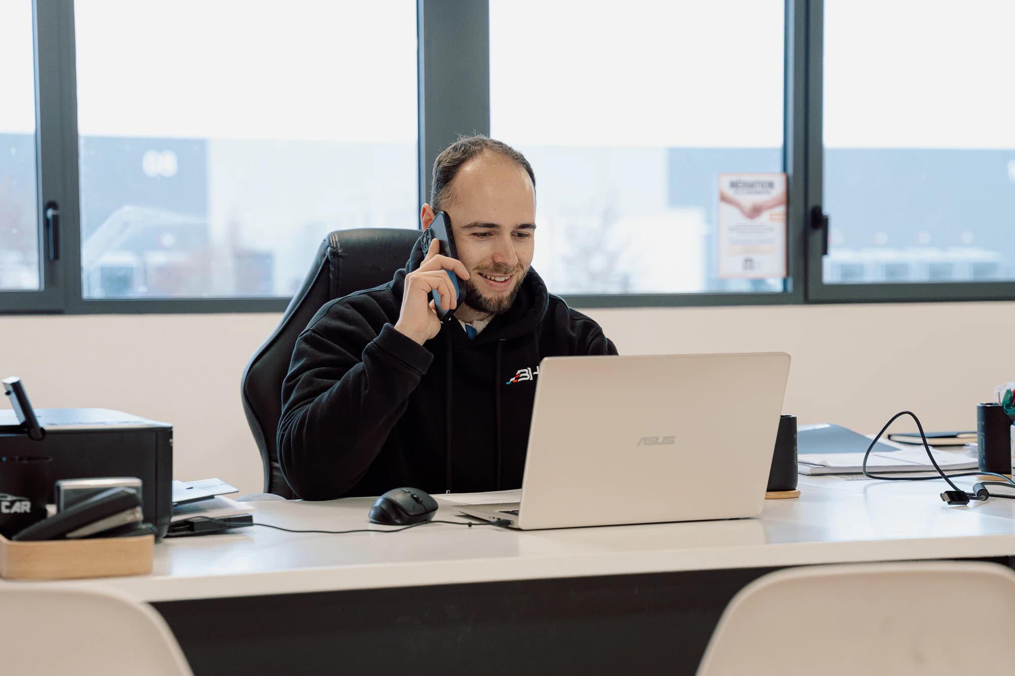 Un conseiller BH au téléphone, à son bureau, devant son ordinateur