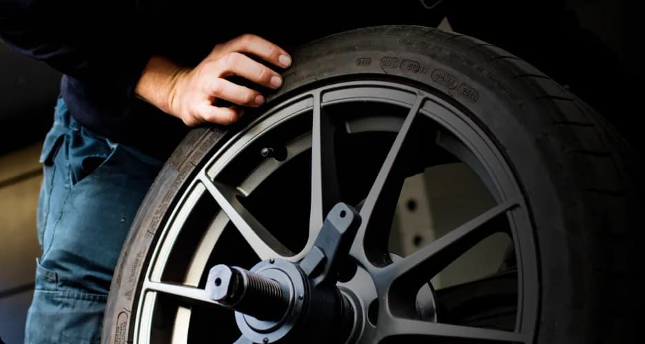 Technicien manipulant une roue en atelier